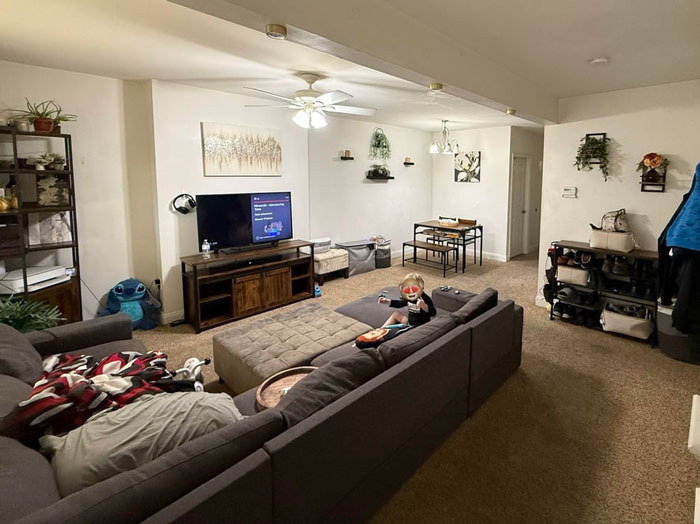 Living room with kids&rsquo; toys and a mom resting on the couch in a lived-in household setting.