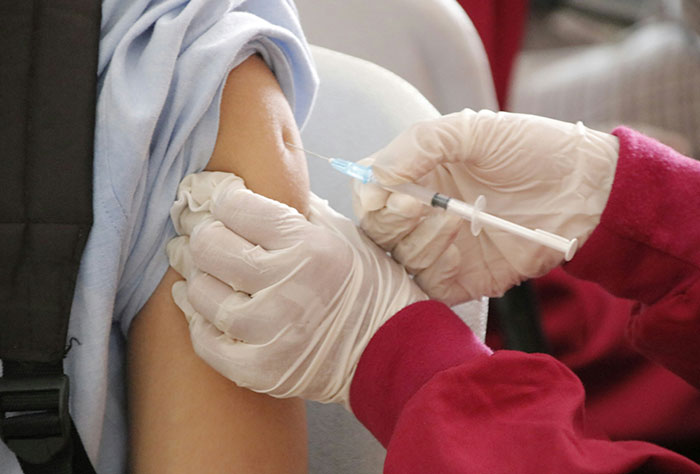 Healthcare worker wearing gloves administering vaccine injection to patient’s upper arm, illustrating Google diagnosis accuracy.