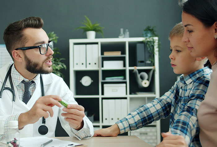 Doctor explaining medication to a child and mother during a medical diagnosis, illustrating Google accuracy in diagnosing people.