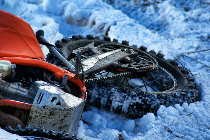 Motorcycle lying in the snow with dirt on tires and body, related to hospital workers sharing creepy experiences.
