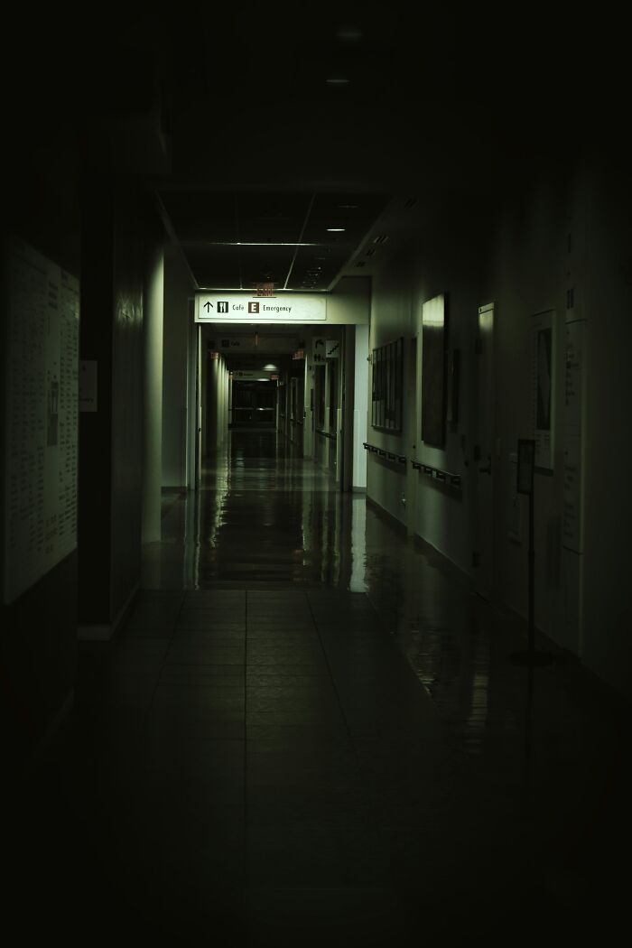 Dimly lit hospital corridor at night, evoking the creepy experiences hospital workers often encounter while working.
