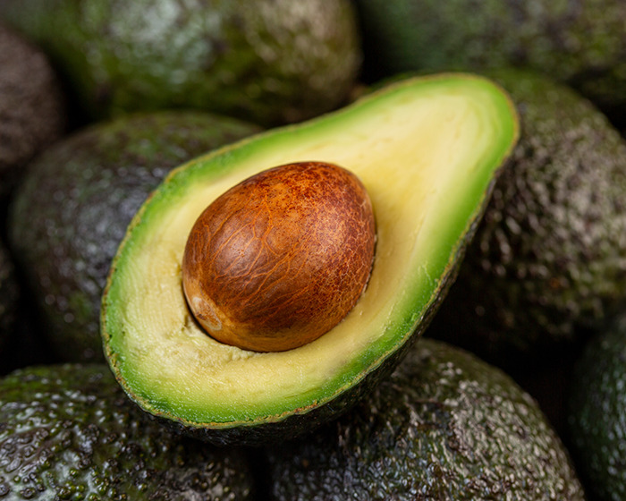 Close-up of a halved avocado with pit, highlighting the avocado hands warning and common kitchen injury risk.