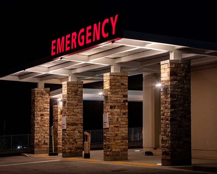 Emergency entrance at night symbolizing thousands visiting ER due to avocado hands injury warning from doctors.
