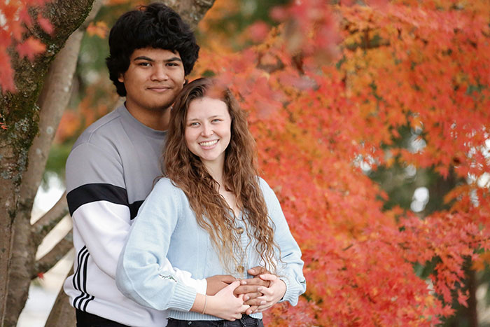 Young couple embracing outdoors during autumn, woman suspects fianc&eacute; is hiding a secret kid after finding kids' clothing.