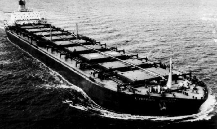 Black and white photo of a large cargo ship navigating ocean waters, related to weird and fascinating things in the ocean.