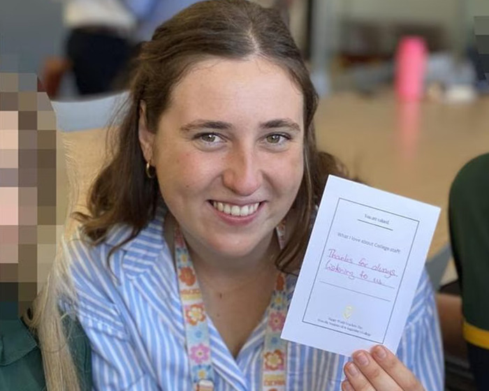 Young woman smiling and holding a card, related to family dinner leads to arrest after dad discovers teen shocking texts with teacher.