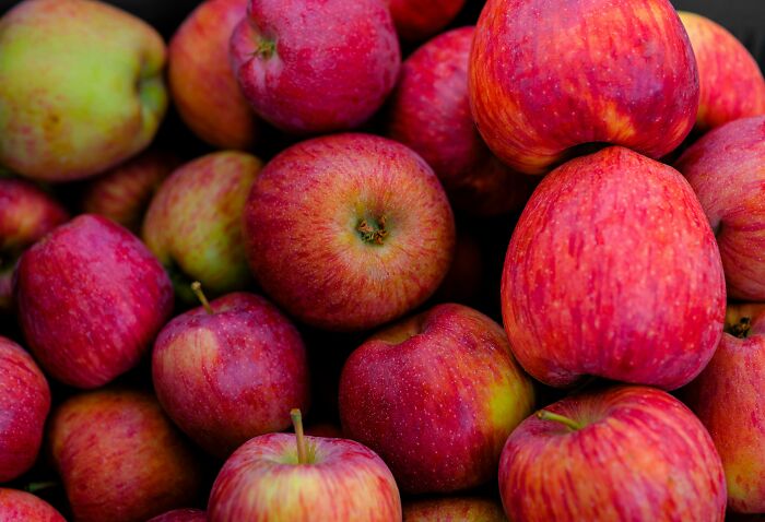 Bright red apples piled together, symbolizing dark secrets that could ruin people’s lives if revealed.