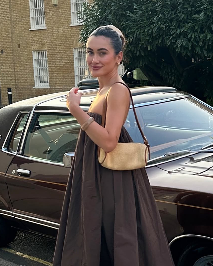 Woman posing by vintage car, sharing story of psychic drawing that allegedly changed her love life quickly.