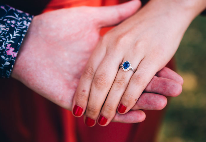 Close-up of hands with a sapphire family heirloom ring, symbolizing a legal dispute over a late son&rsquo;s fianc&eacute;.
