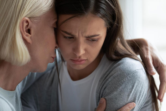 Mother comforting upset daughter, showing regret and emotional connection in a heartfelt family moment.