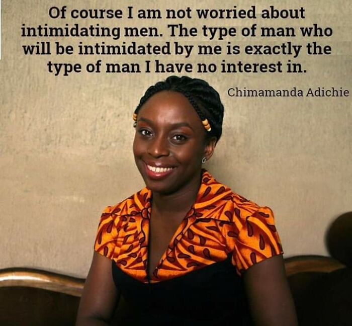 Smiling woman with braided hair wearing an orange patterned top, alongside a feminist quote about intimidating men and patriarchy.
