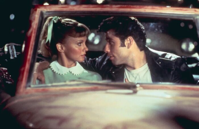 Couple inside a car showing a classic unrealistic women movie trope scene with a retro 1950s style and lighting.