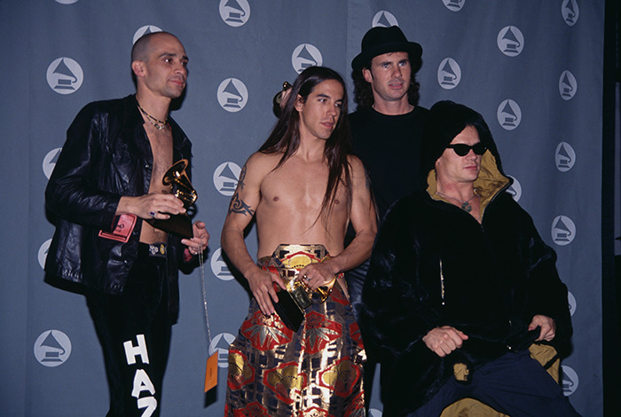 Former Red Hot Chili Peppers star posing with awards, highlighting their current homelessness and GoFundMe help plea.