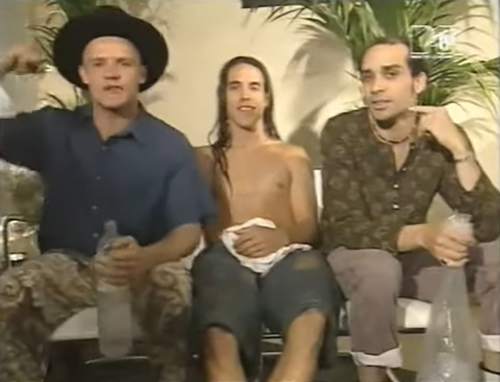 Former Red Hot Chili Peppers star sitting with bandmates in a casual setting, seeking help to escape homelessness.