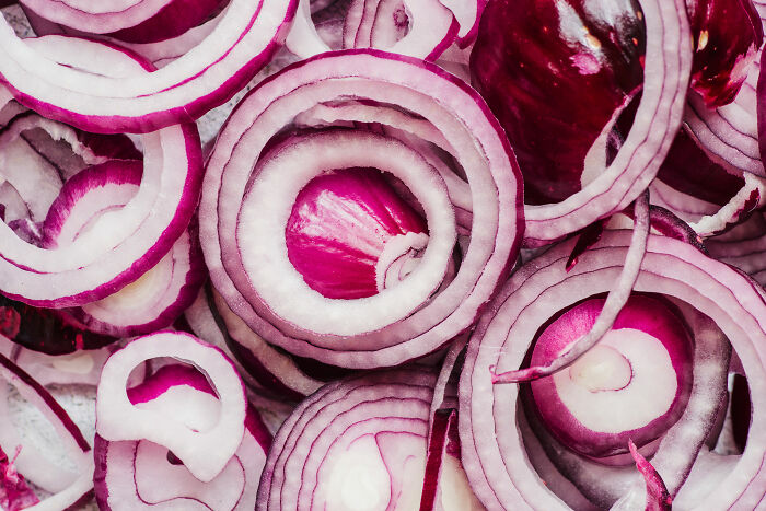 Close-up of sliced red onions illustrating strange and dumb health hacks shared by patients with doctors and nurses.