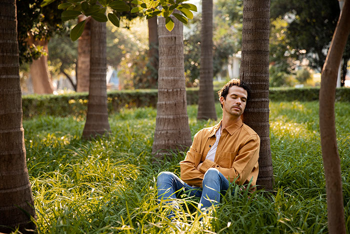 Man sitting alone in a park looking uneasy, reflecting the creepy feeling of finding secret photos taken without consent.