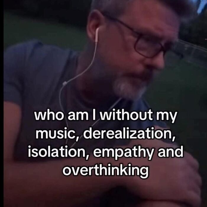 Man with glasses and earphones reflecting on anxiety symptoms including derealization, isolation, empathy, and overthinking in a relatable meme.
