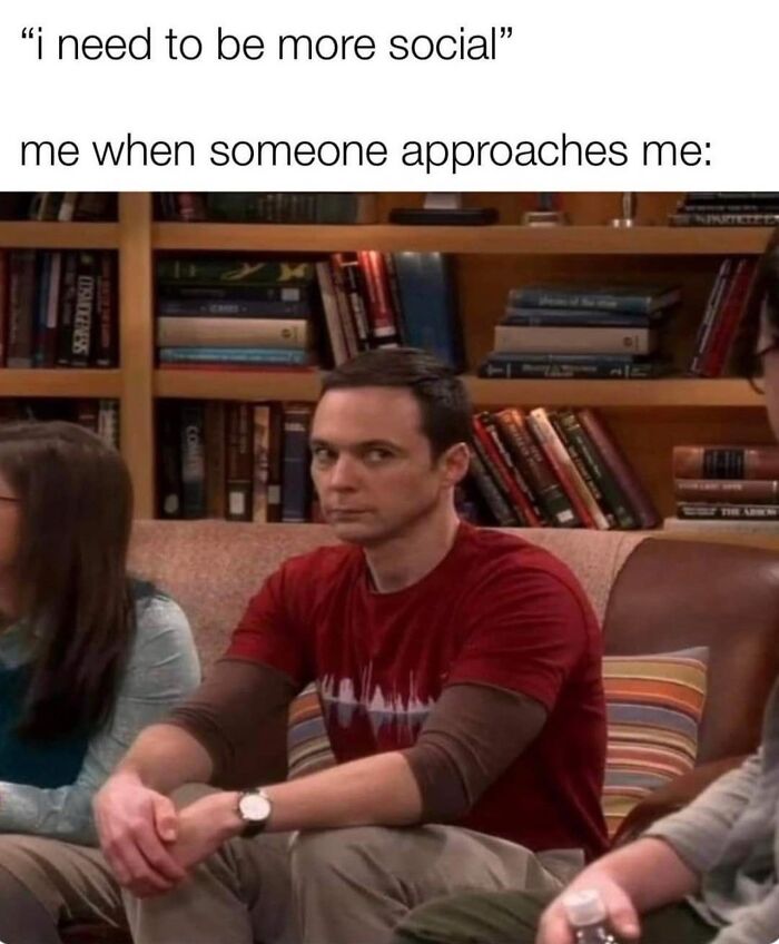 Man in a red shirt sitting awkwardly on a couch, illustrating relatable memes to help cope with anxiety.