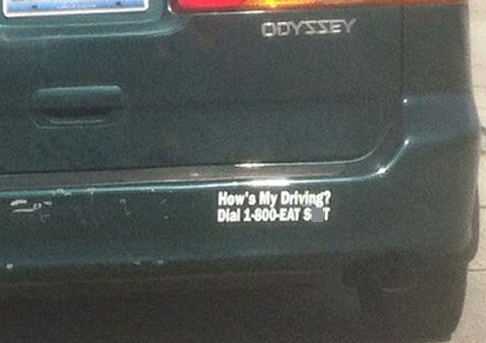 Bumper sticker on a car reading how's my driving dial 1-800-EAT S T showing funny drivers' stickers on the road.