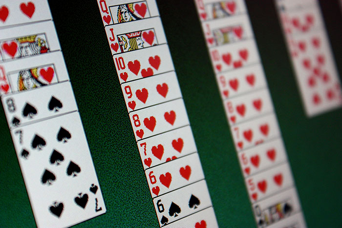 Close-up of a computer screen showing a digital card game, illustrating older people clueless with technology online.