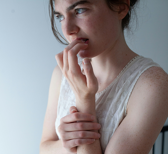 Woman looking worried and biting nails, expressing emotions related to friendship and being a bestie bank.