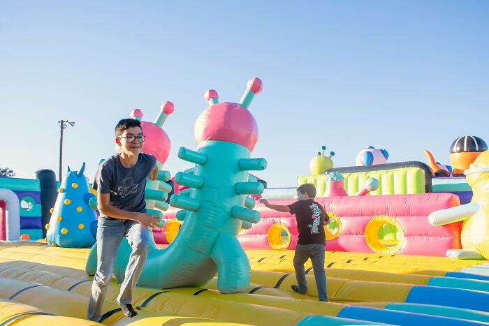 Two boys playing on a colorful inflatable obstacle course, capturing moments of fun and instant karma experiences.