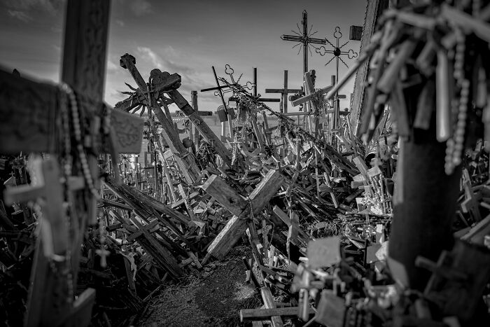 Spooky destination with numerous wooden crosses and rosaries under a cloudy sky, perfect for Halloween visits.