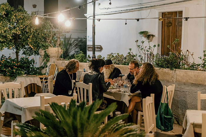 Group of people dining outdoors at night, highlighting Bulgarian and Dutch food culture differences and sharing customs. Group of people dining outdoors at night, highlighting Bulgarian and Dutch food culture differences and sharing customs.