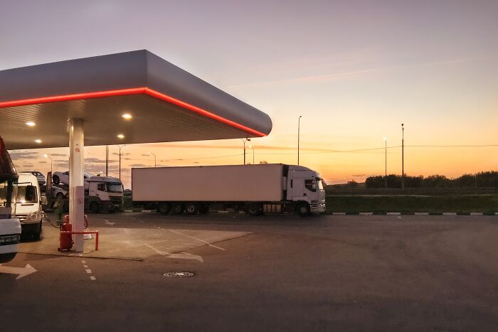 Large truck parked at a gas station during sunset, evoking unexplainable creepy things people experienced vibes.