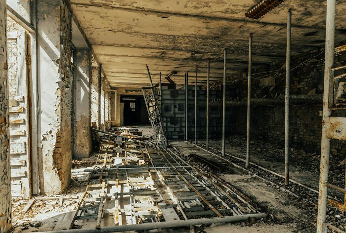 Abandoned building interior with rusted metal framework and peeling walls, evoking a near-death experiences atmosphere.