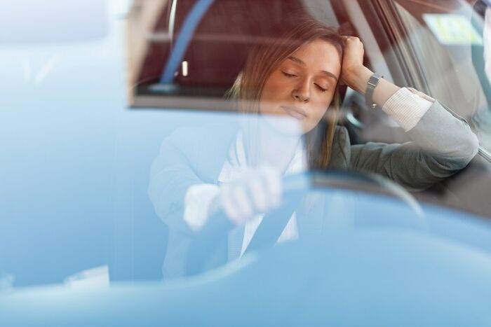 Woman asleep behind the wheel of a car, illustrating a moment related to near-death experiences witnessed firsthand.