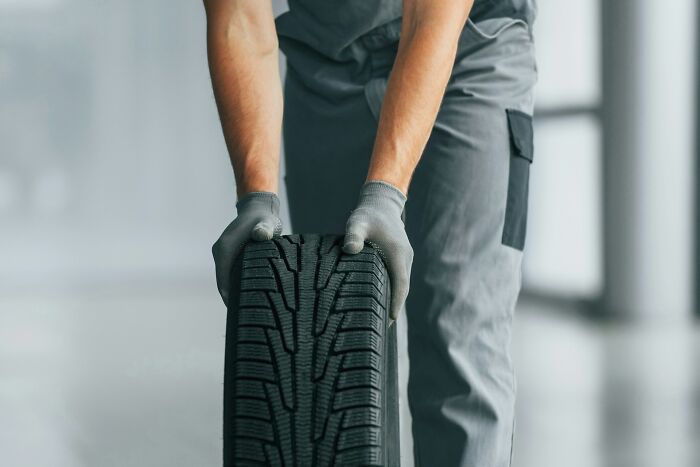 Person wearing gloves and holding a tire, illustrating moments related to near-death experiences and how they happened.