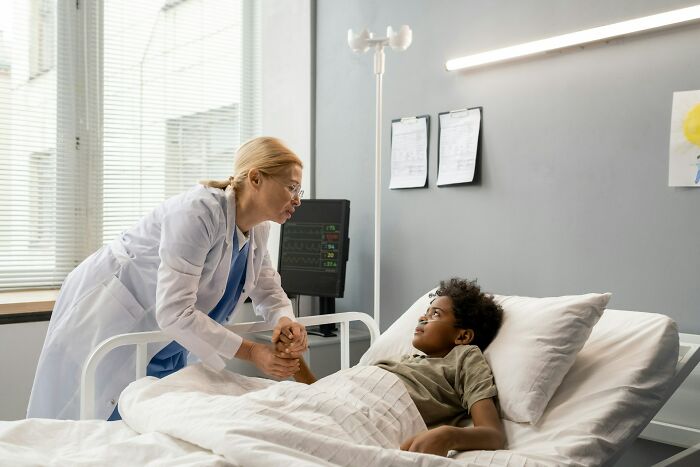 Doctor comforting a young patient in a hospital bed, illustrating moments from near-death experiences and their impact.