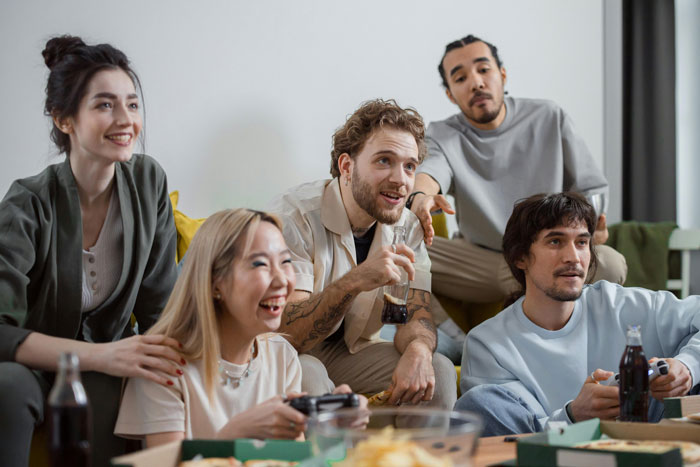 Group of friends enjoying a casual hangout, highlighting relationship tension around trip with female friend concerns.