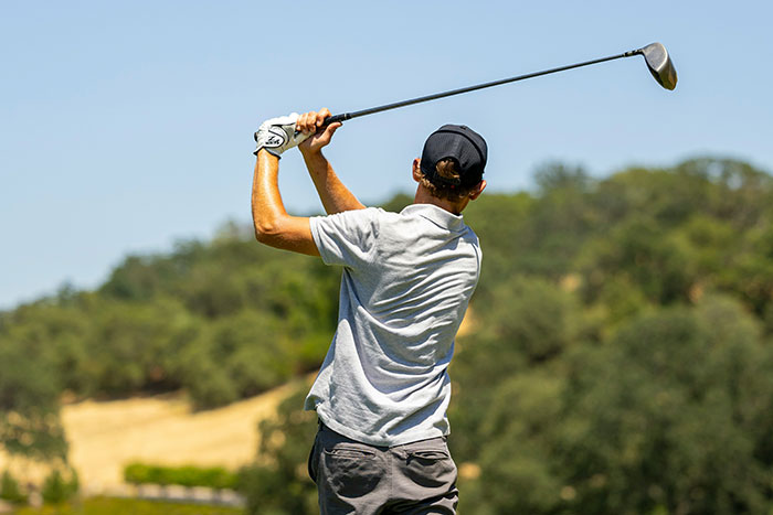 Person playing golf outdoors, illustrating moments people with famous family members share as they found out and experienced.