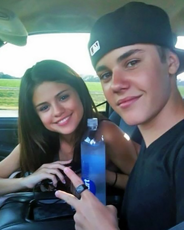 Selena Gomez and Justin Bieber sitting in a car, smiling and posing for a selfie together.
