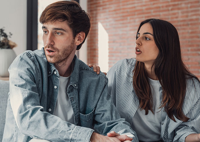 Young man looks uncomfortable while girlfriend talks to him, illustrating masculinity so fragile impacting their relationship.