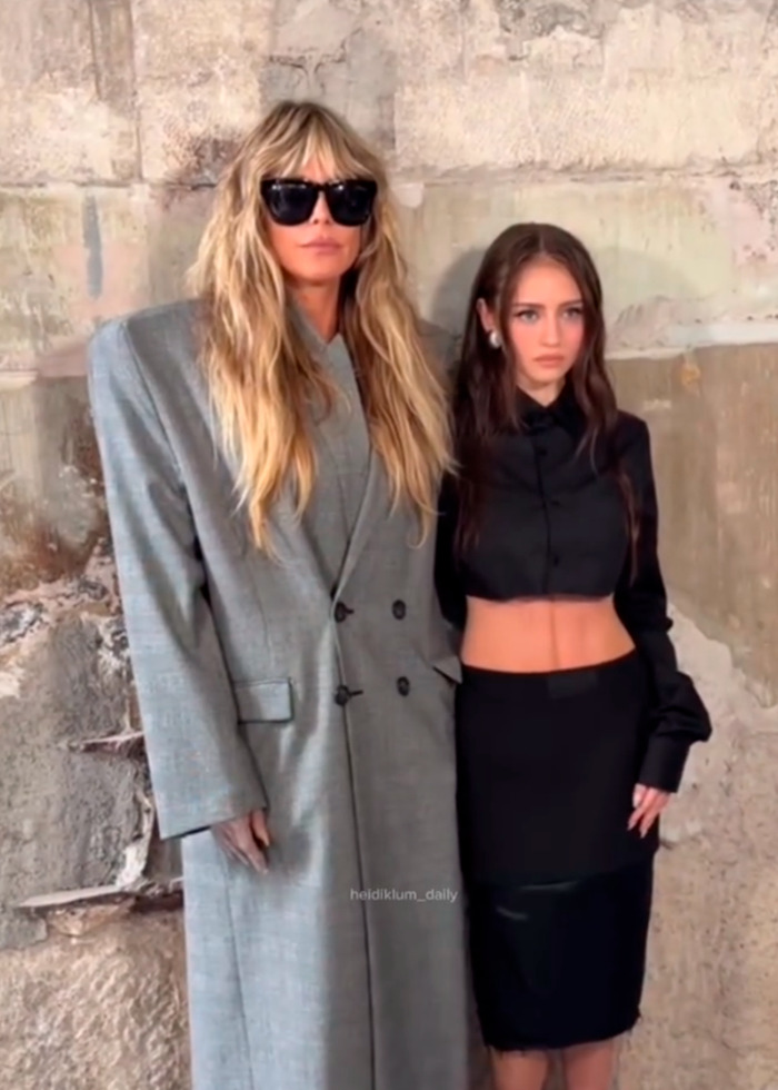 Heidi Klum wearing a sheer dress with thong detail posing with a woman in black at Vetements Paris fashion show.