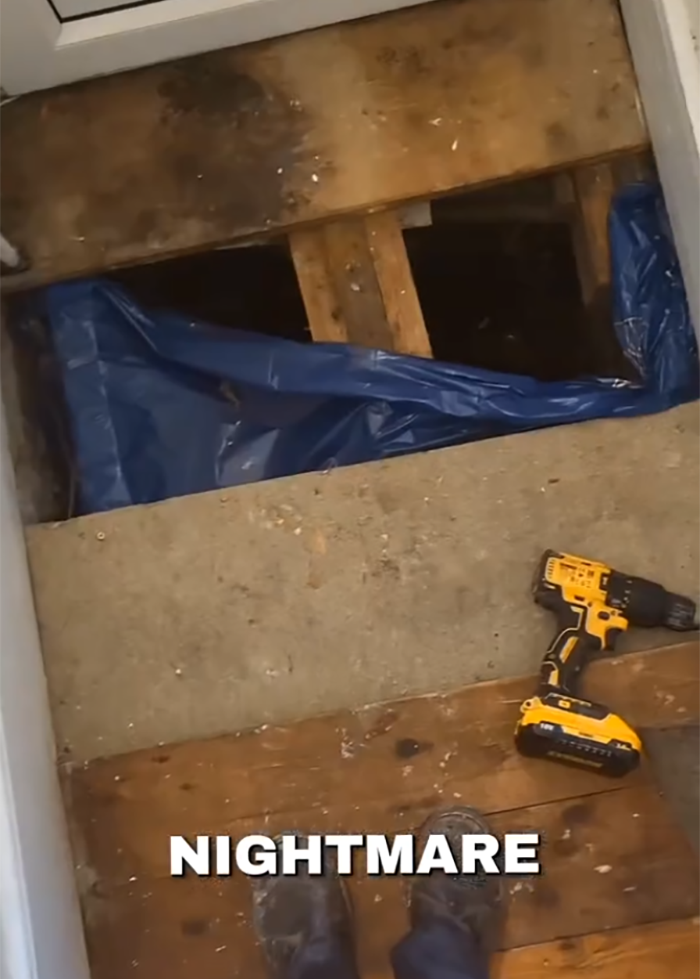 Exposed floorboards revealing a hidden feature under the floor with a drill and worn shoes nearby in a new home.