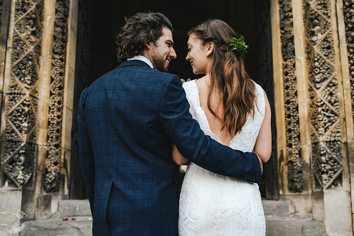 A stylish couple embraces outside an ornate building, highlighting the charm of the most famous supermodel in the world.