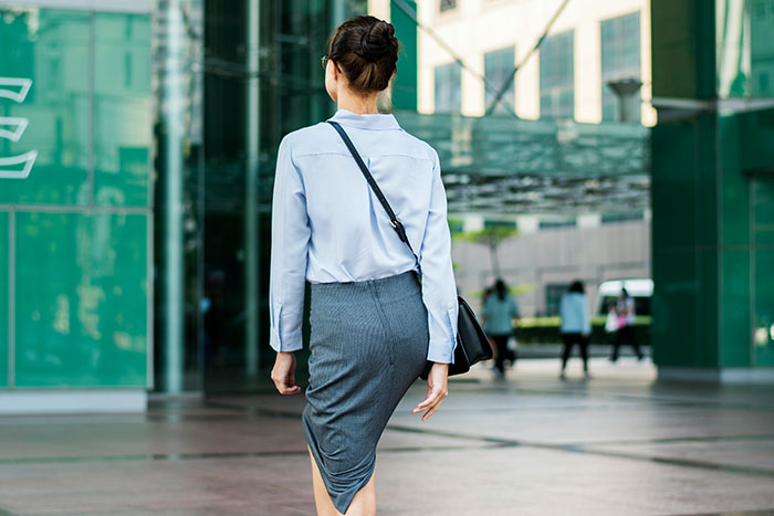 Woman walking confidently outdoors in business attire, representing the most famous supermodel in the world concept.