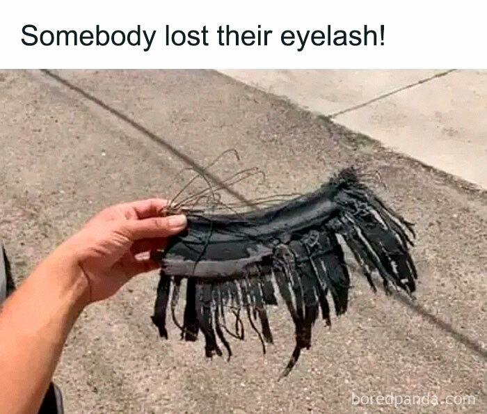 Hand holding a large shredded piece of tire rubber resembling a lost eyelash in a relatable funny meme.