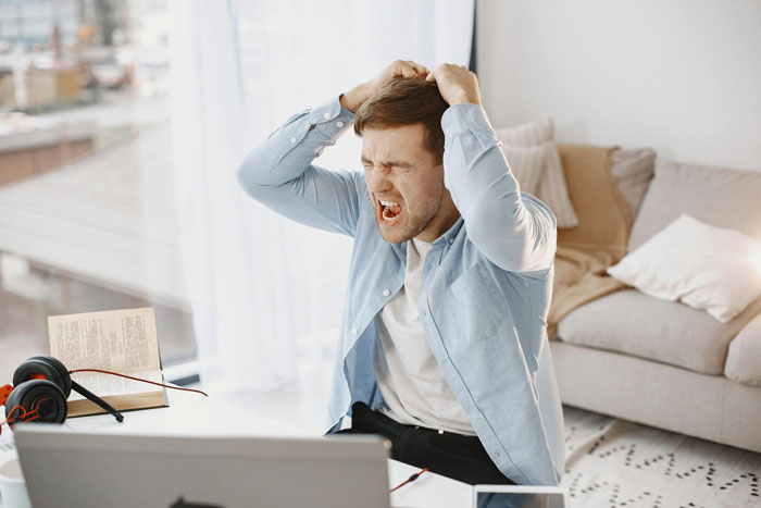 Man expressing frustration at home, clutching his head in anger, reflecting heartless ex furious with pregnant wife feelings. Man expressing frustration at home, clutching his head in anger, reflecting heartless ex furious with pregnant wife feelings.