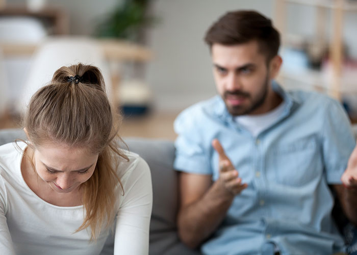 Woman upset after husband disputes her, reflecting tension over tummy tuck savings in a home setting.