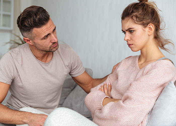Man and woman in a tense conversation, illustrating common icks that make men lose interest in a woman.