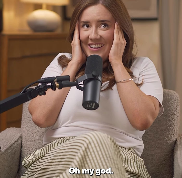 Woman sharing pro revenge story on cheating boyfriend, smiling and speaking into microphone during a casual podcast session.