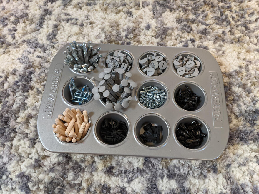 Organized small hardware pieces sorted in a muffin tin as a simple home organization hack method.