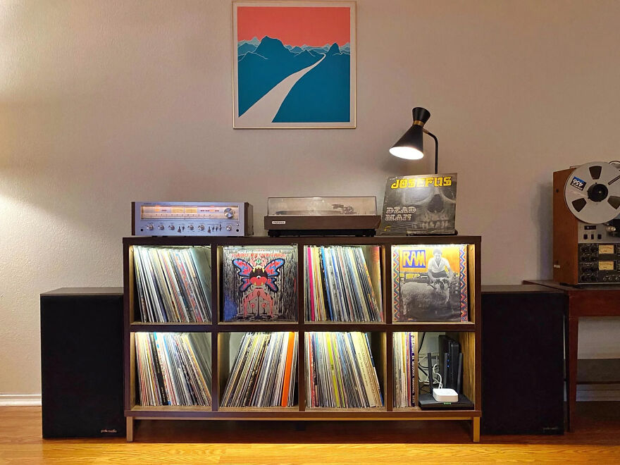 Organized vinyl record storage in a wooden shelf with speakers, turntable, and framed art showcasing smart organization hacks.