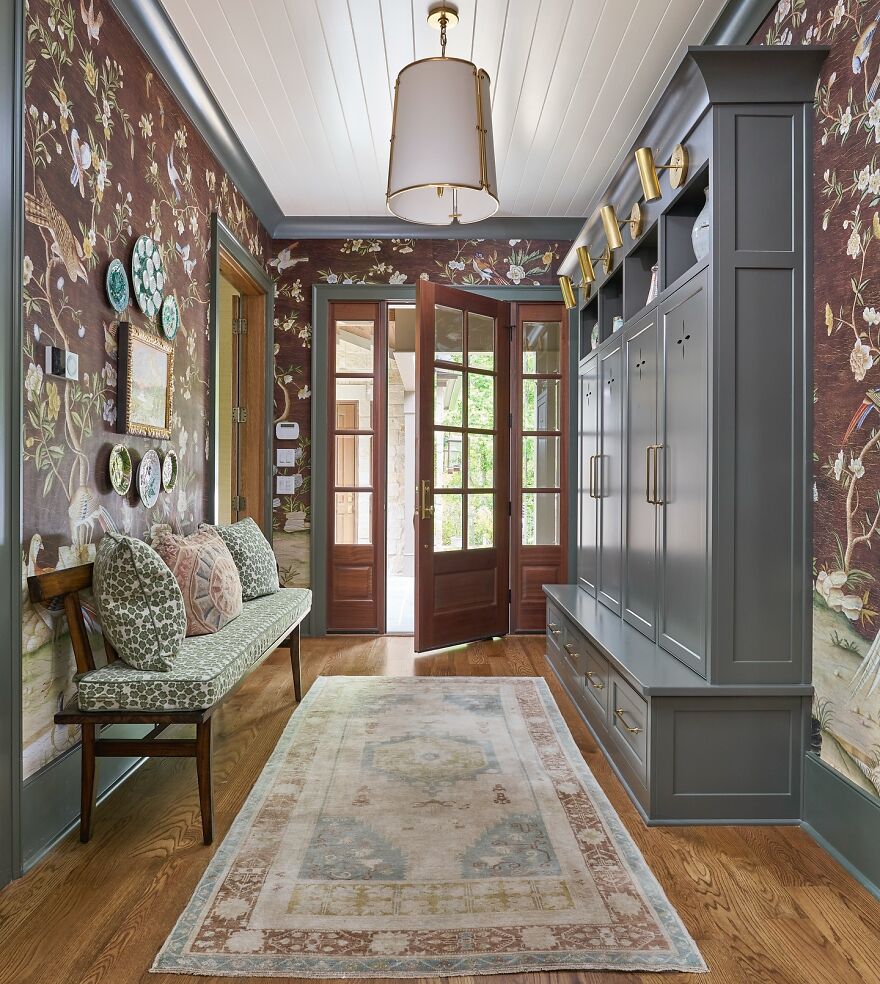 Organized stylish entryway with built-in cabinets, seating bench, and decorative wall accents for better home organization.