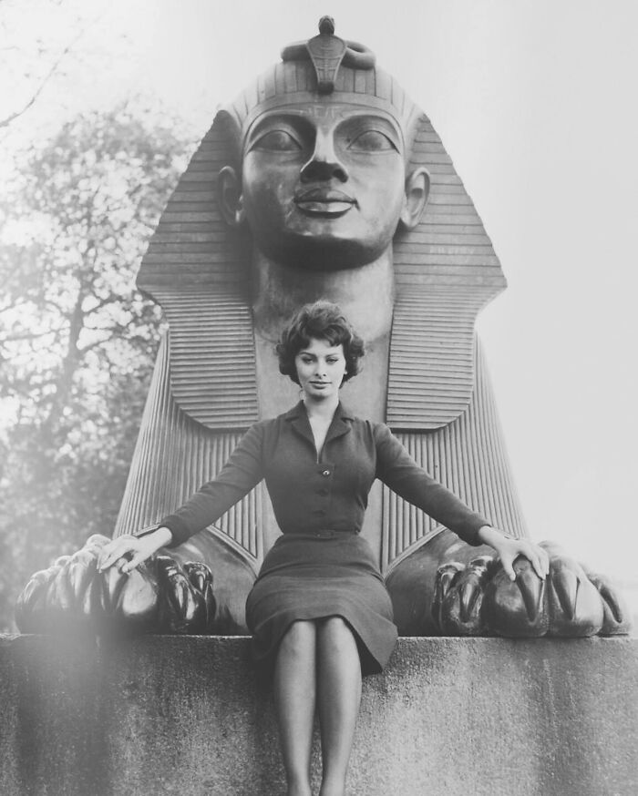 Sophia Loren posing in front of a large Egyptian sphinx statue, showcasing classic Italian beauty and elegance.